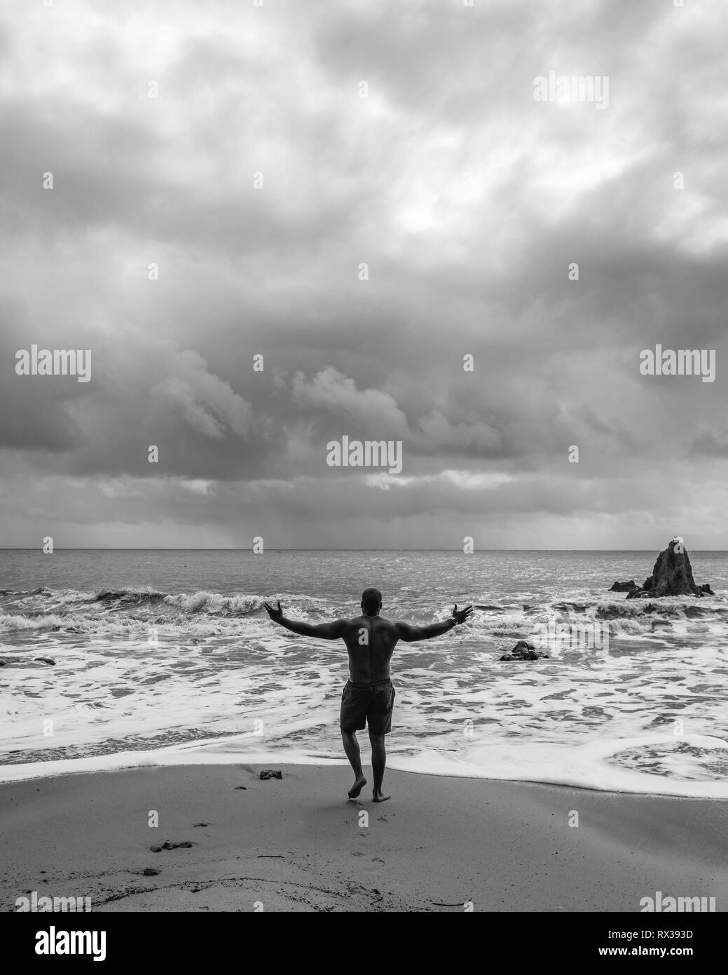 Un homme toute la puissance de l'océan pendant un orage sur El Matador Beach, en Californie. Banque D'Images