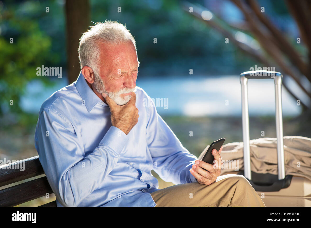 Senior homme barbu message entrant dans le parc. Banque D'Images