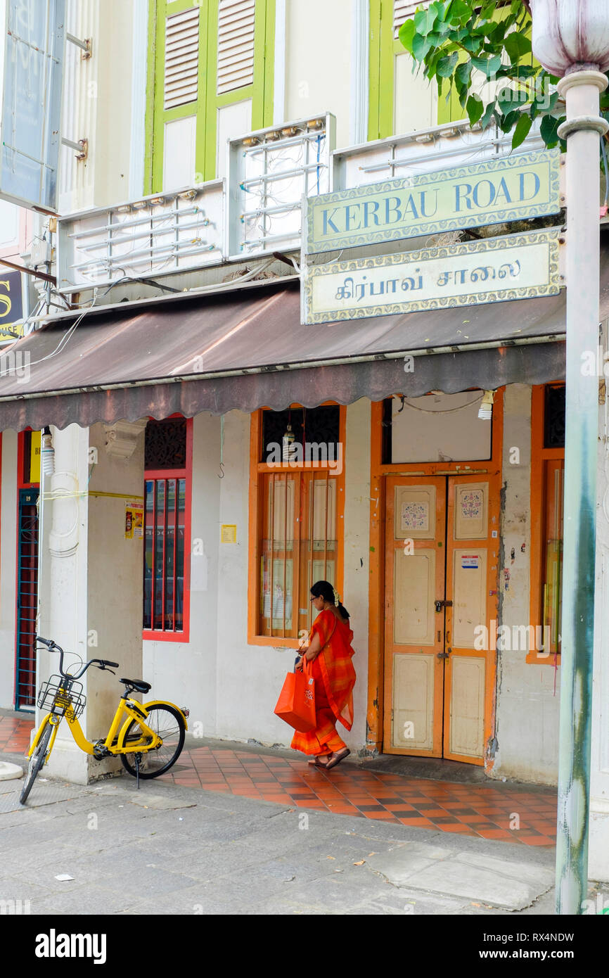 Femme et location vélo jaune qui fait partie de Singapour au programme vélo garé en rue dans Little India à Singapour Banque D'Images