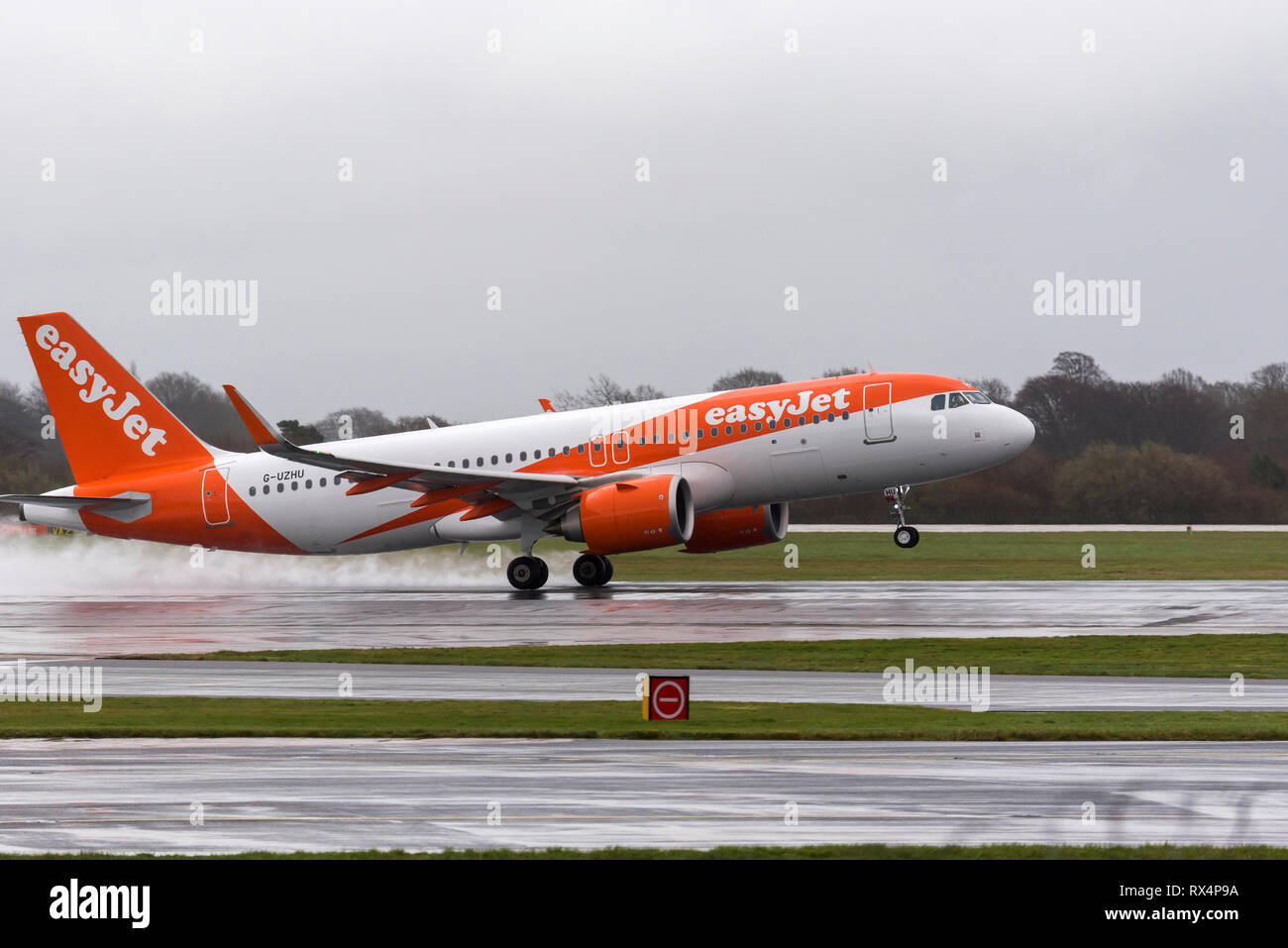 Décollage d'Airbus easyJet sur piste mouillée à l'aéroport de Manchester. Banque D'Images