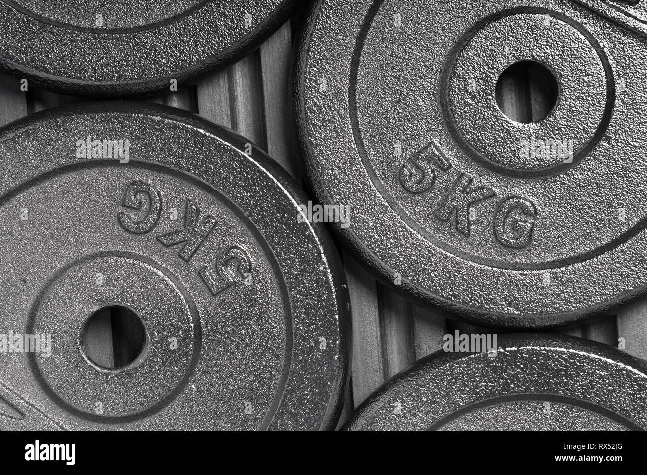 Les plaques de poids sur un sol en caoutchouc noir à l'intérieur d'une formation de poids salle de sport / fitness studio Banque D'Images
