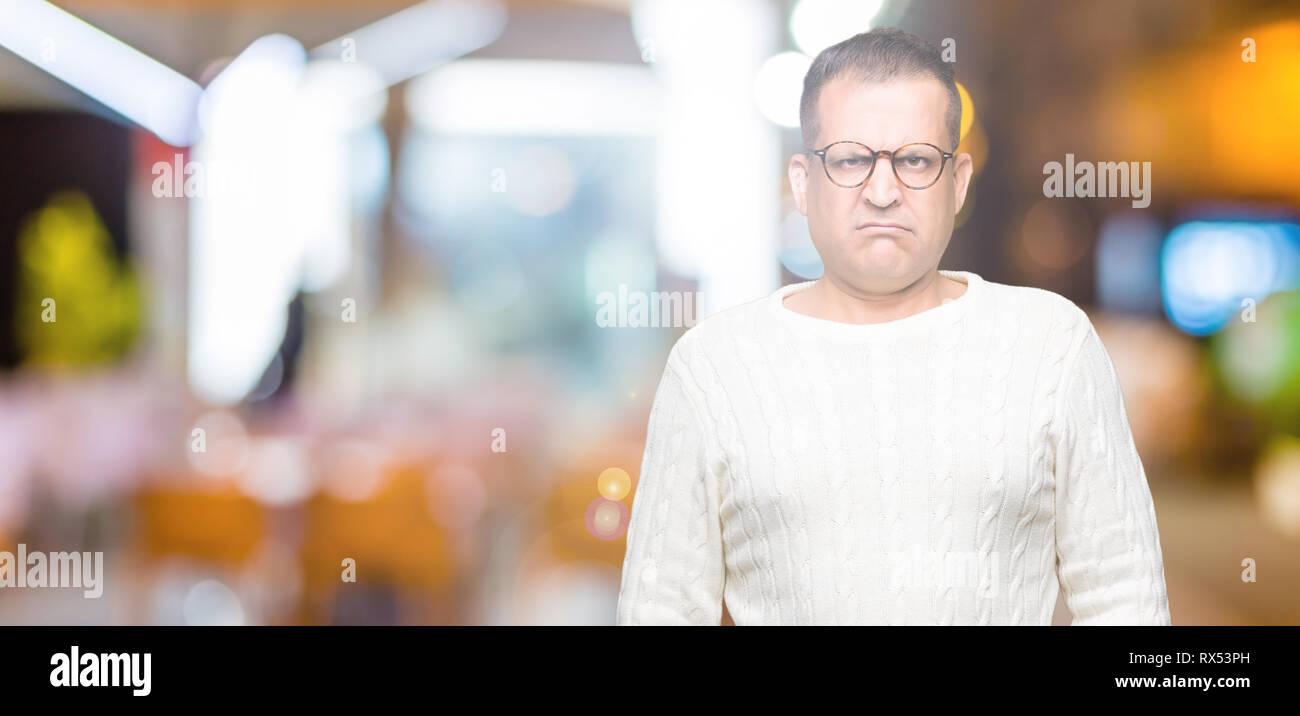 L'âge moyen de l'homme arabes portant des lunettes au fond isolé sceptique et nerveux, fronçant bouleversé parce que de problème. Personne négative. Banque D'Images