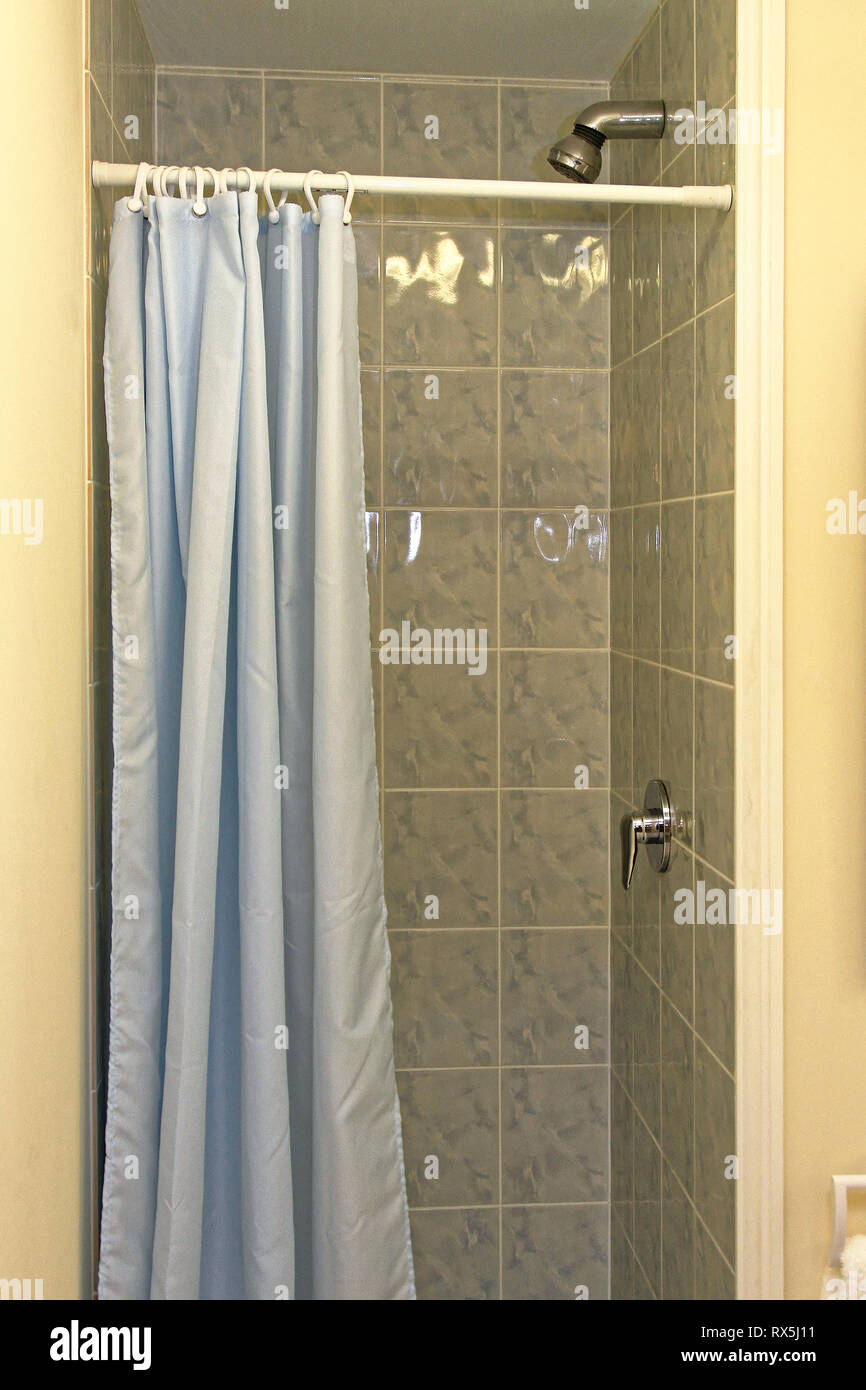 Petite cabine de douche avec rideaux bleus Banque D'Images