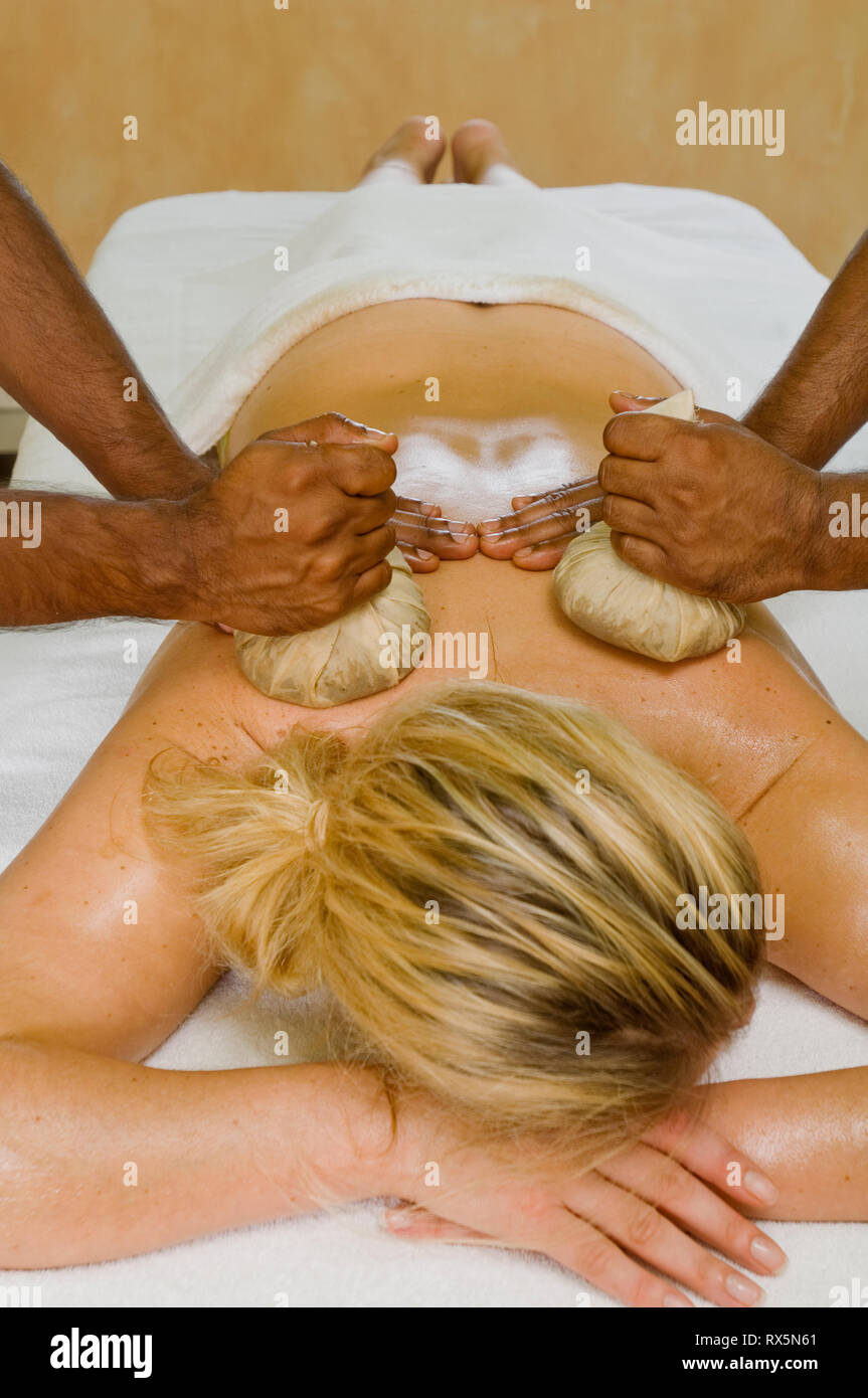 Femme massée avec des compresses aux herbes Banque D'Images
