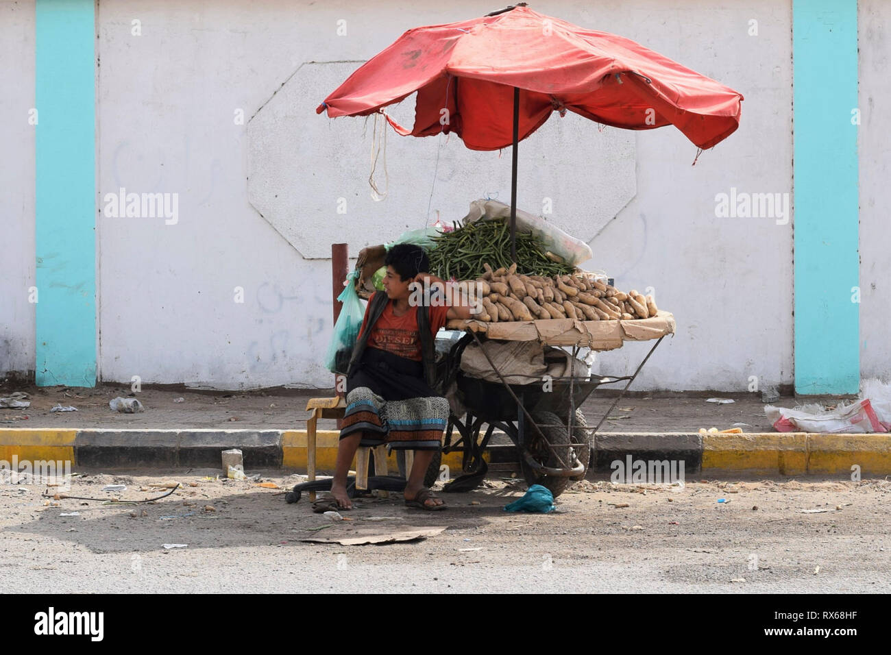 D'Aden, au Yémen. Mar 8, 2019. Un enfant est assis à côté d'un stand du vendeur dans une rue d'Aden, la capitale du Yémen, le 8 mars 2019. Des milliers de jeunes Yéménites ont été poussées dans les rues à la suite d'un conflit militaire croissante qui a éclaté entre les forces du gouvernement du Yémen et les rebelles Houthi en 2015. Le nombre d'enfants des rues continue d'augmenter sur une base quotidienne que les combats se poursuivent, l'expansion pour inclure un plus grand nombre de provinces dans le pays arabe au milieu de l'absence de solutions politiques à la fin de quatre ans de guerre civile. Credit : Murad Abdo/Xinhua/Alamy Live News Banque D'Images