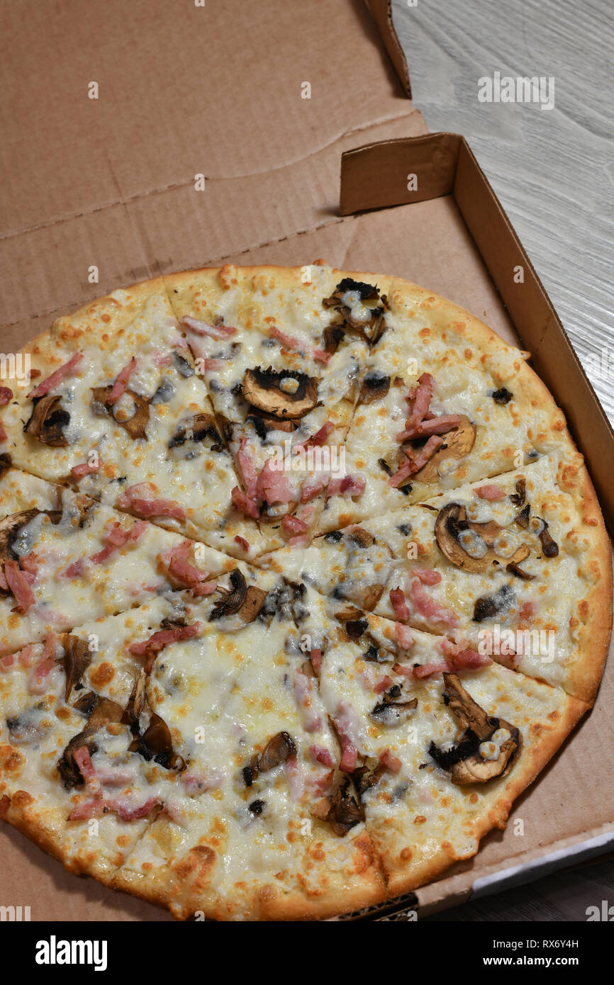 Pizza aux champignons et au jambon en boîte de carton Banque D'Images