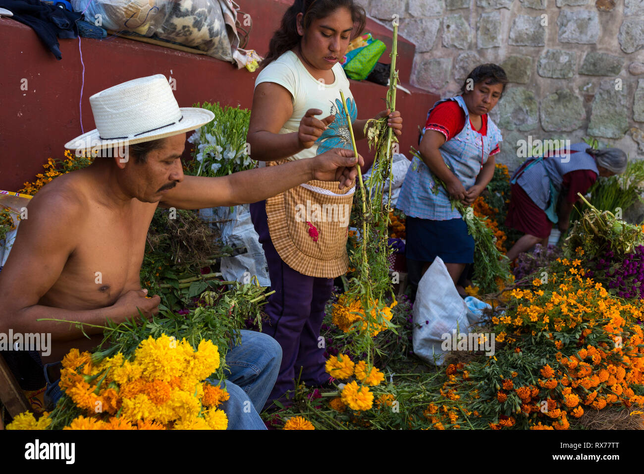 Une famille vend des fleurs pour les offrandes le jour de la mort. Banque D'Images