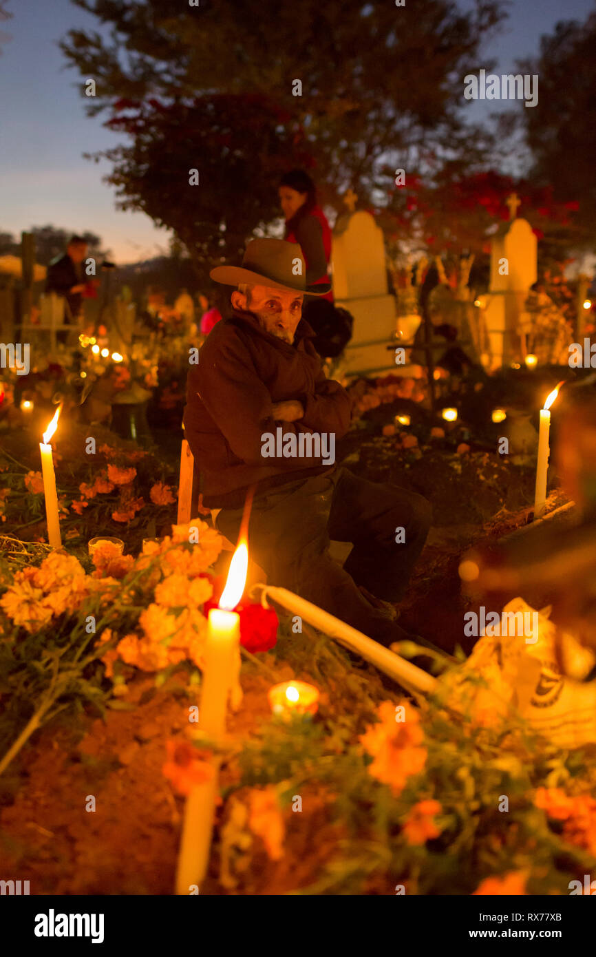 Un homme passe la nuit accompagnant la tombe d'un de leurs parents morts. Banque D'Images