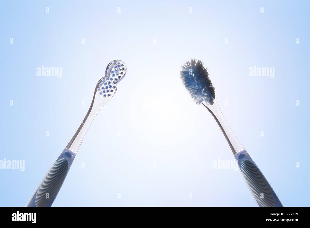 Comparaison entre nouveaux et utilisés avec brosse à dents isolées bleu arrière-plan. Vue de face. Composition horizontale. Banque D'Images