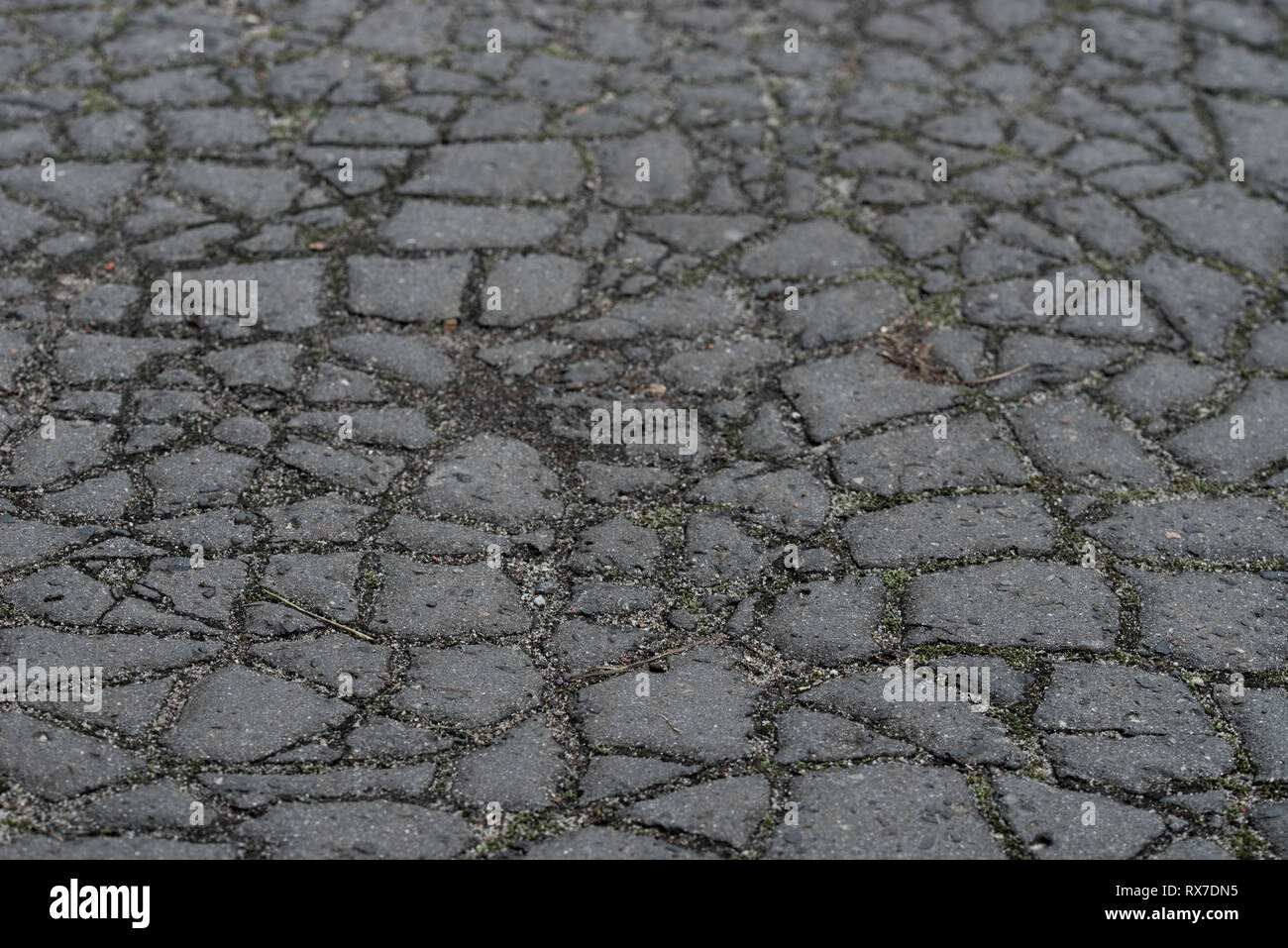 Texture de fond d'asphalte fissurée sombre selective focus Banque D'Images