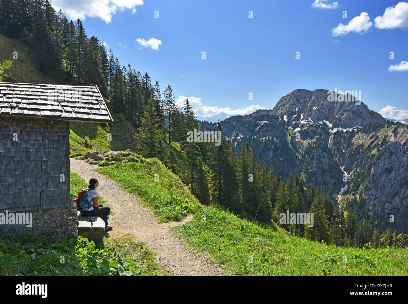 Jeune femme assise sur un banc et profiter de la vue dans les Alpes à une belle journée de printemps. La Bavière, Allemagne Banque D'Images
