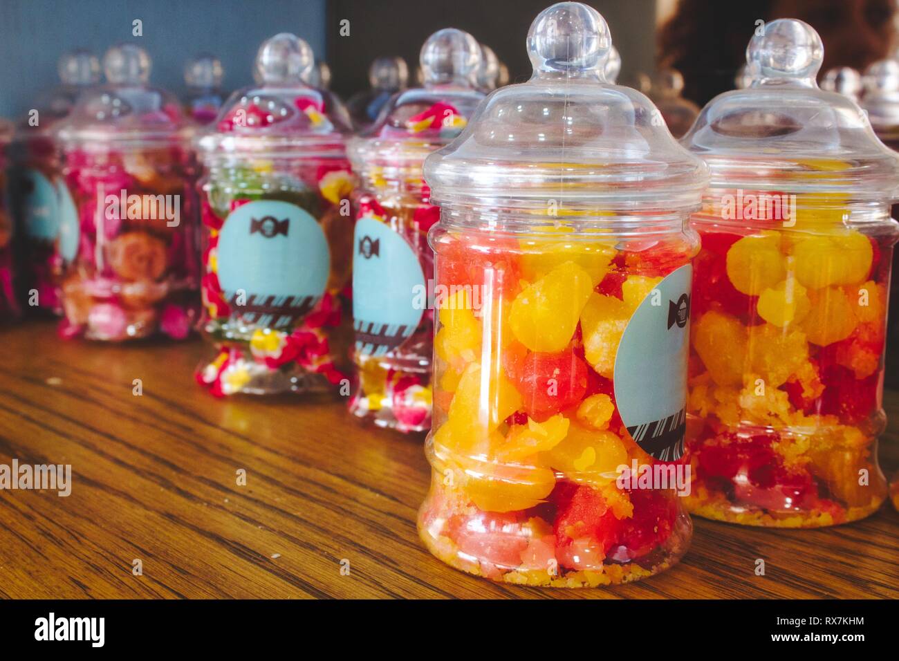 Bonbons colorés dans des pots en plastique sur une étagère dans un sweet shop Banque D'Images