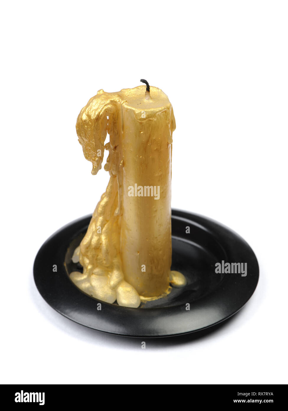 Vieille bougie de cire d'or sur un socle noir sur fond blanc isolé Banque D'Images