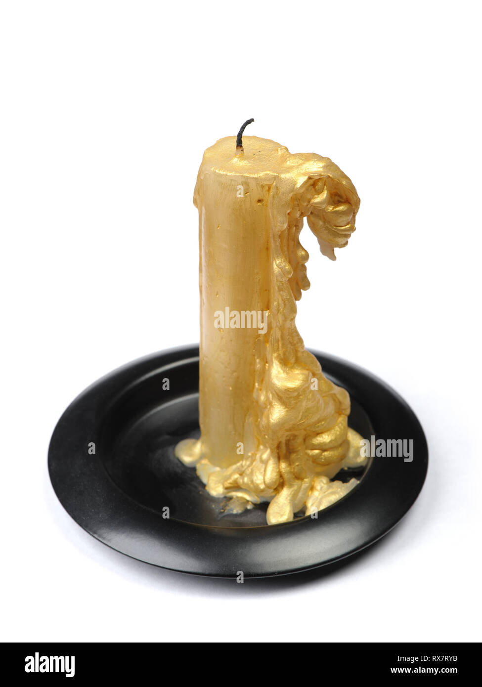 Vieille bougie de cire d'or sur un socle noir sur fond blanc isolé Banque D'Images