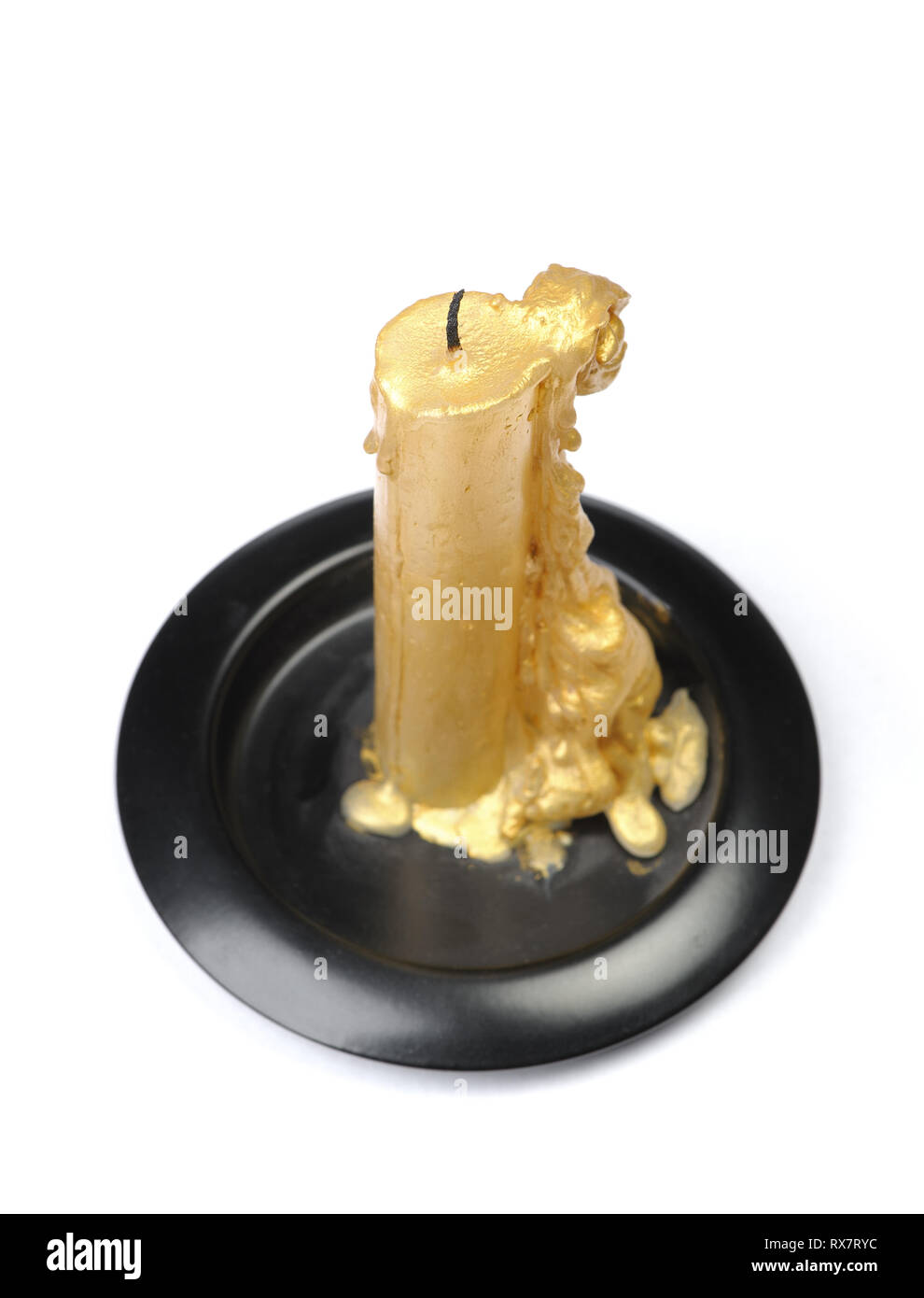 Vieille bougie de cire d'or sur un socle noir sur fond blanc isolé Banque D'Images