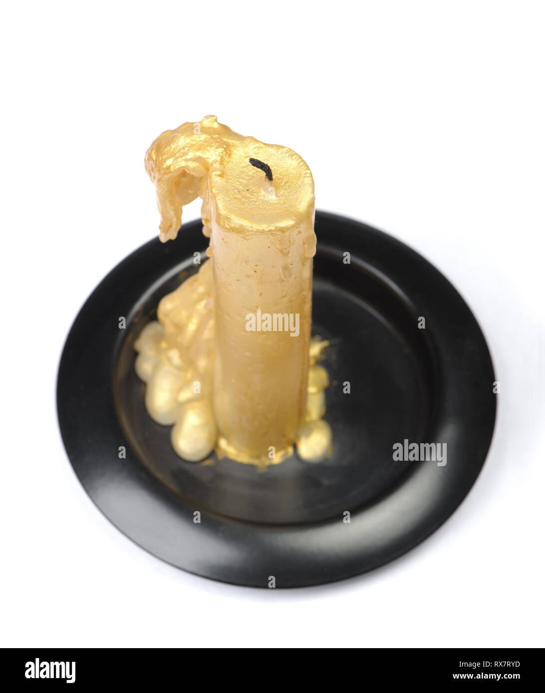 Vieille bougie de cire d'or sur un socle noir sur fond blanc isolé Banque D'Images