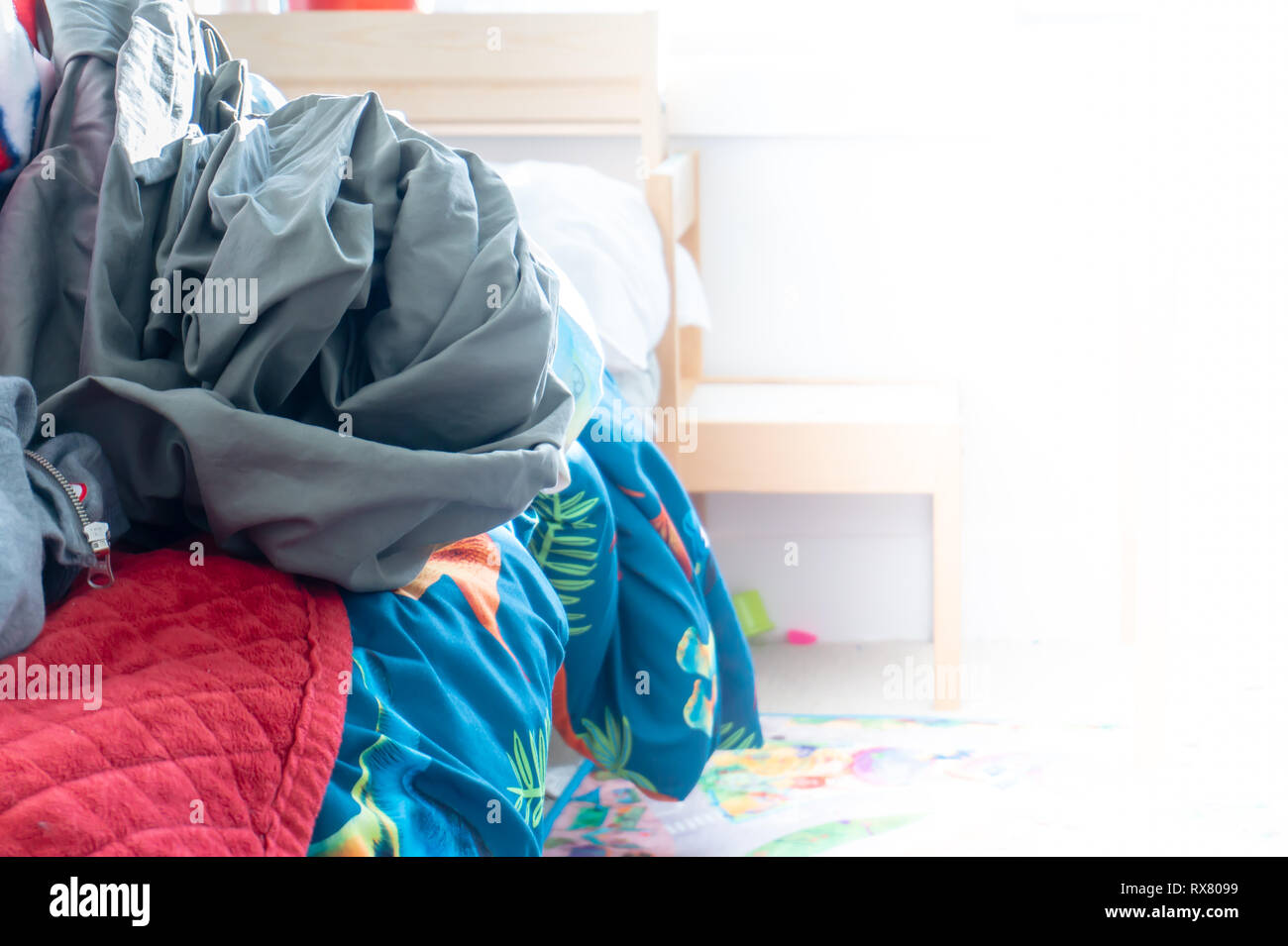 Chambre du garçon malpropre réel montrant messy bed avec pile de draps froissés. Prix pour la copie et l'espace blanc sur la droite. Banque D'Images