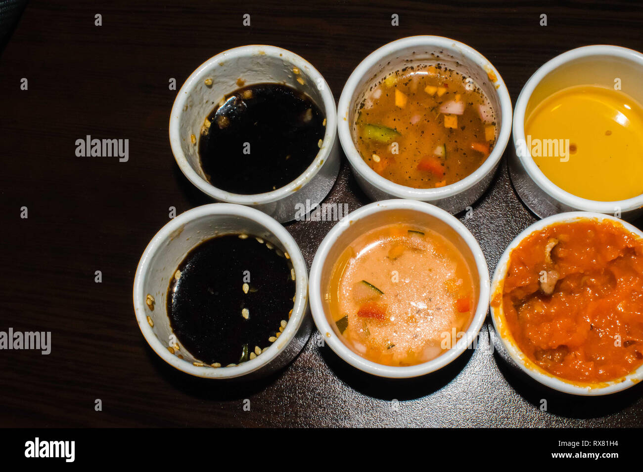 Différents types de sauce sur les restaurants asiatiques placés sur de petits bols disposés dans une rangée Banque D'Images