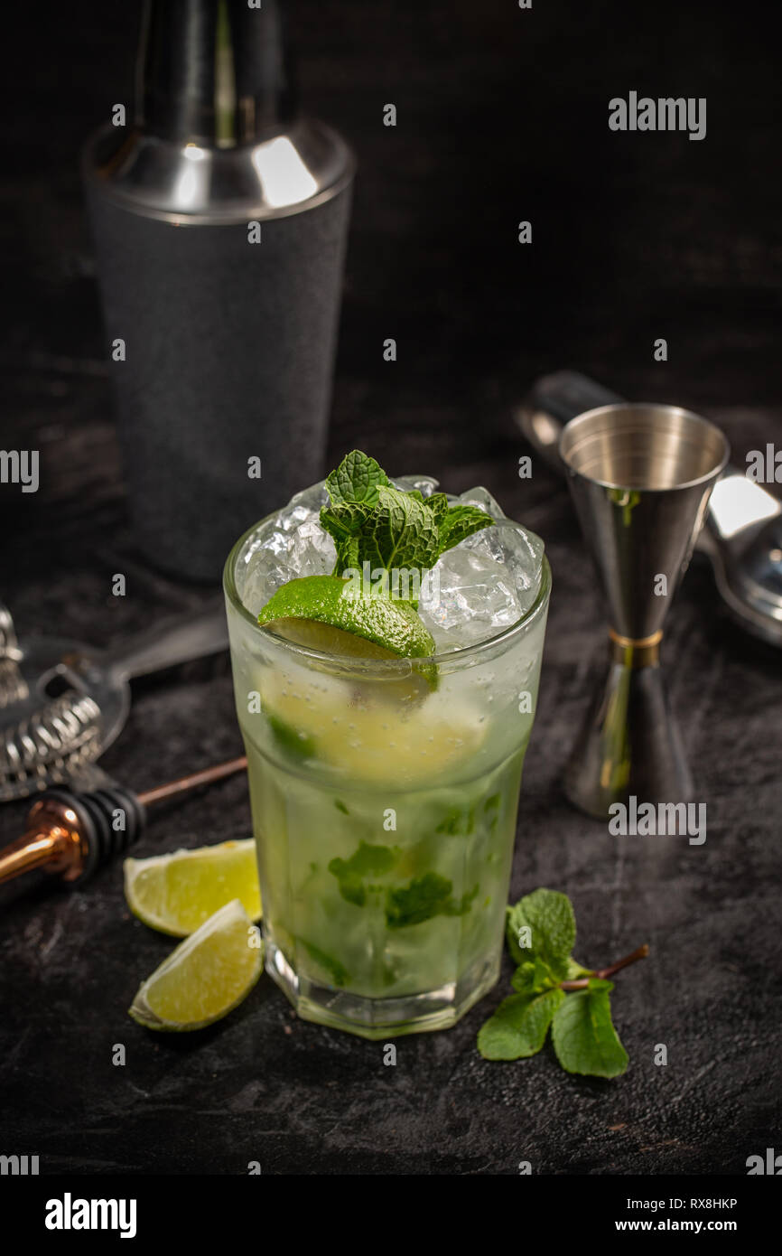 Mojito cocktail en verre avec limes et outils de barman situées près de Banque D'Images