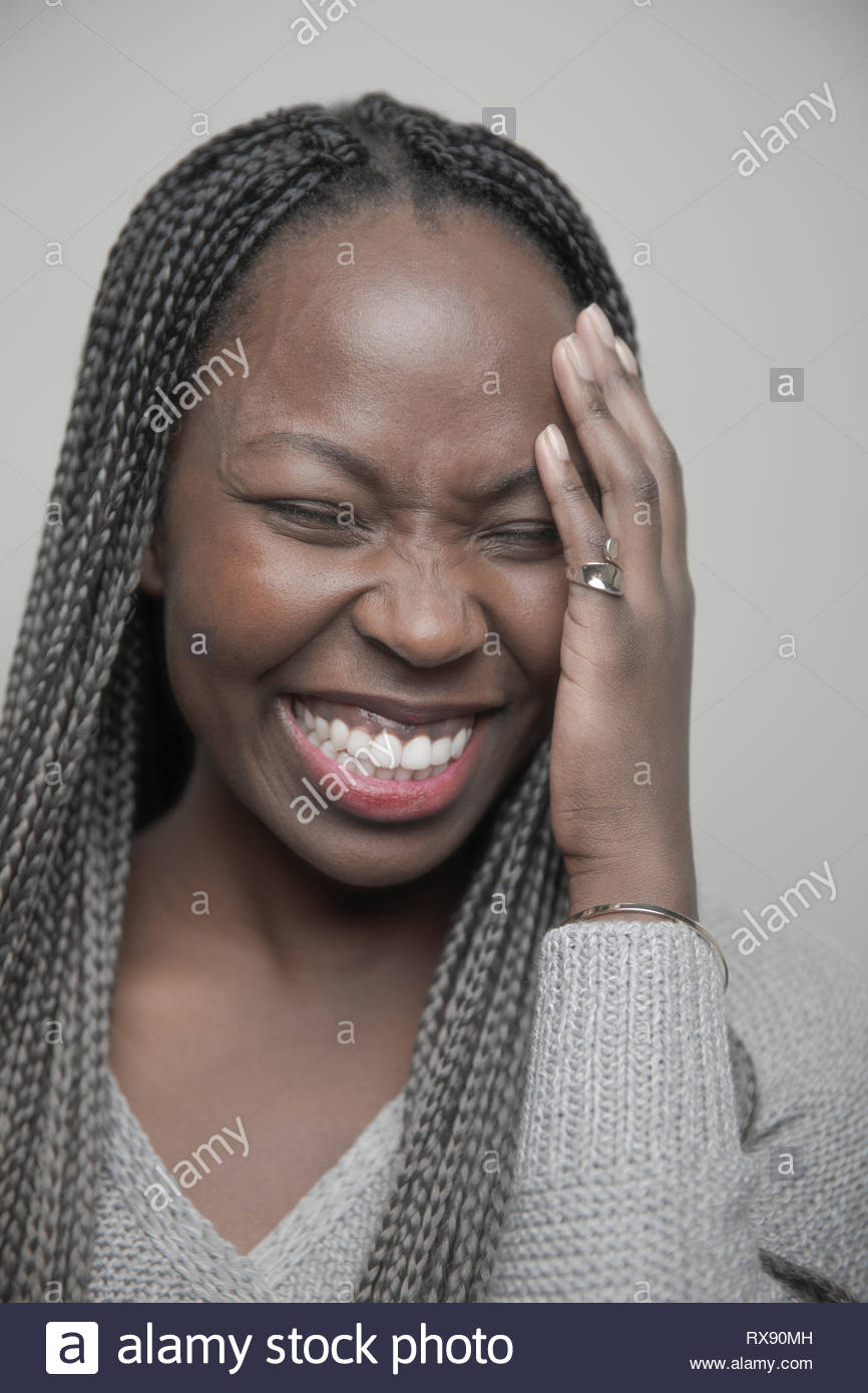 Carefree Portrait belle jeune femme africaine avec de longues tresses noires laughing Banque D'Images