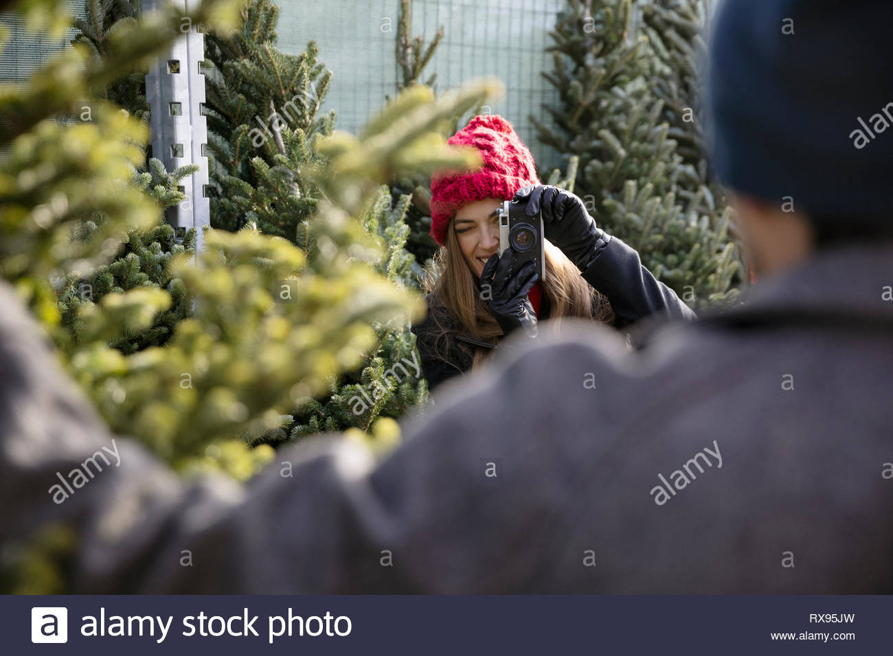 Femme avec caméra photographiant copain avec arbre de Noël Marché de Noël Banque D'Images