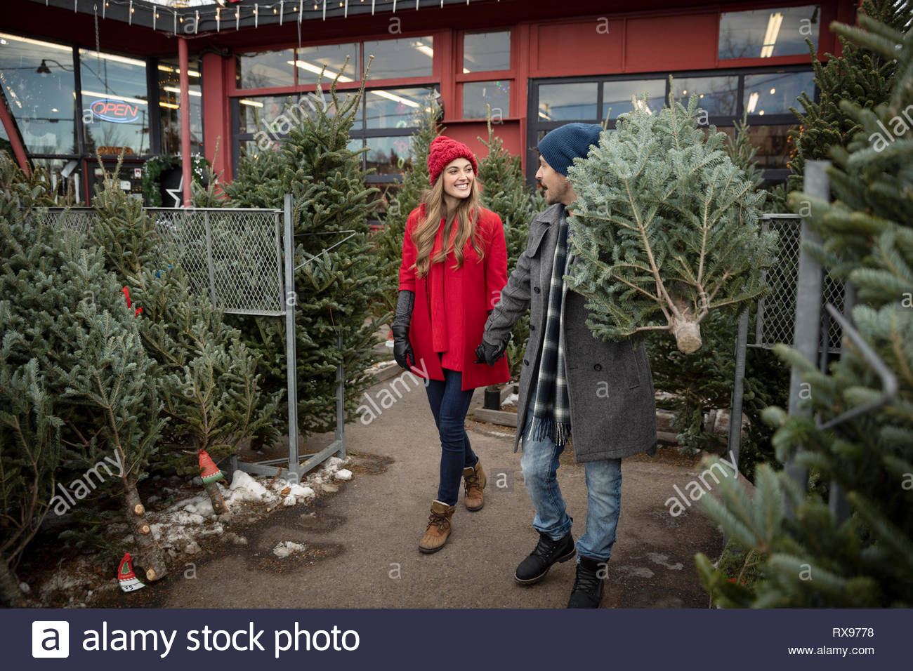 Couple carrying Christmas Tree at Christmas market Banque D'Images
