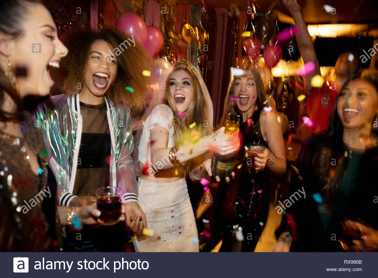 Confettis tombant de rire et bachelorette friends in nightclub Banque D'Images
