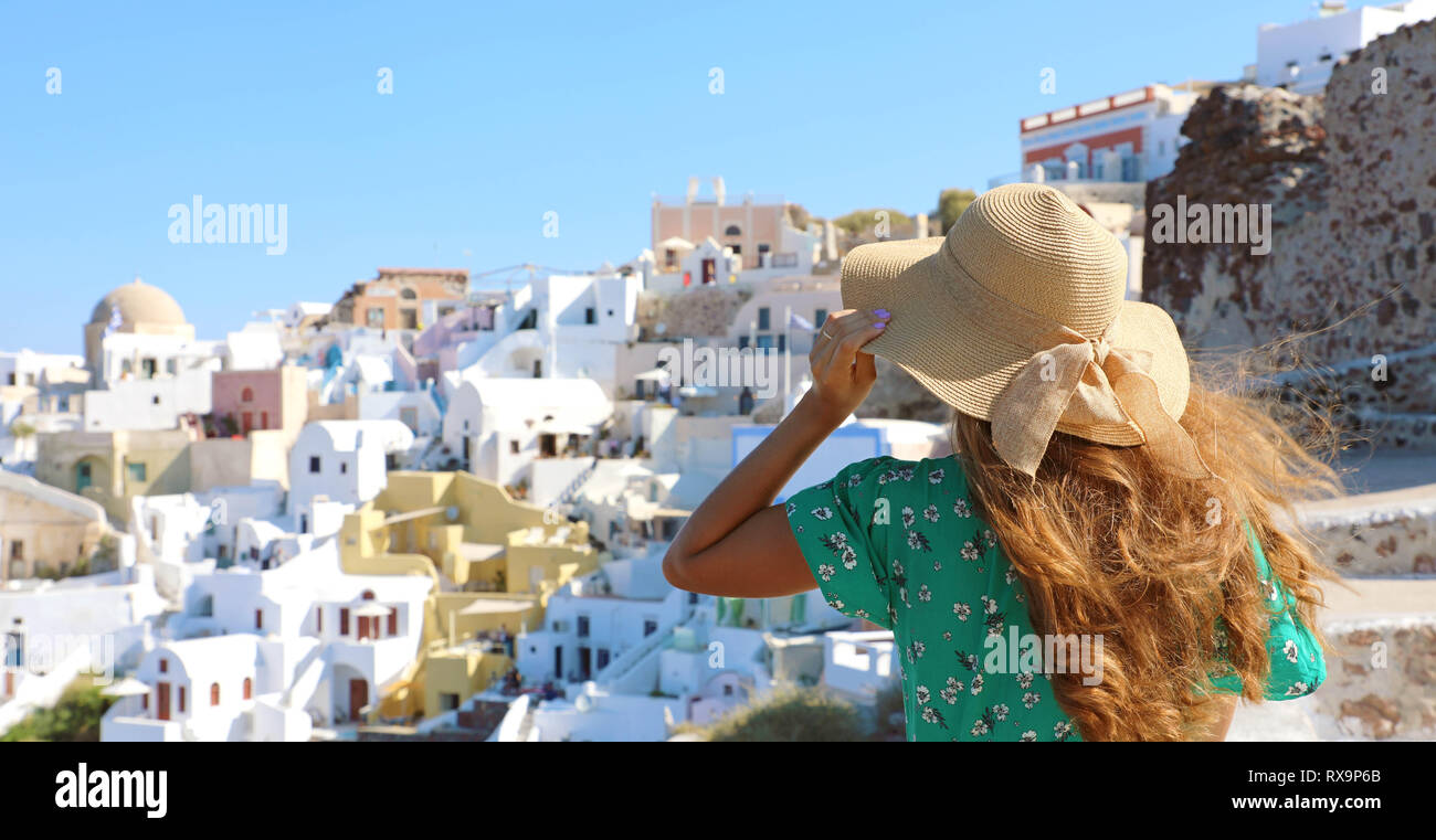 Tourist traveler girl à Oia, Santorin en Grèce. Europe travel vacances d'woman holding her hat et bénéficiant d'une vue panoramique. Banque D'Images