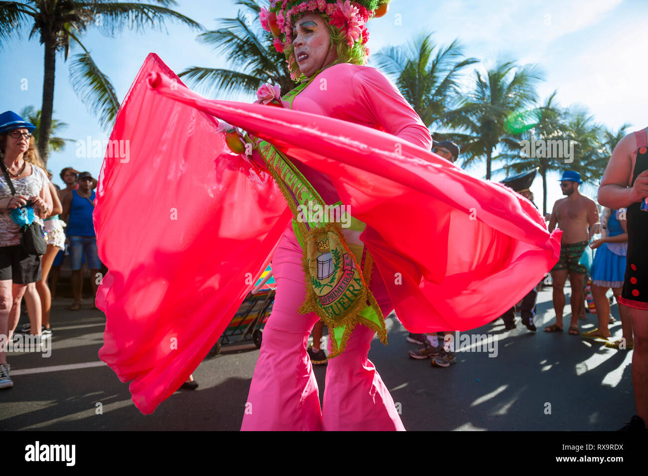 RIO DE JANEIRO - février 11, 2017 : un homme en costume rose flamboyant danses pour les spectateurs à un carnaval fête de rue à Ipanema. Banque D'Images