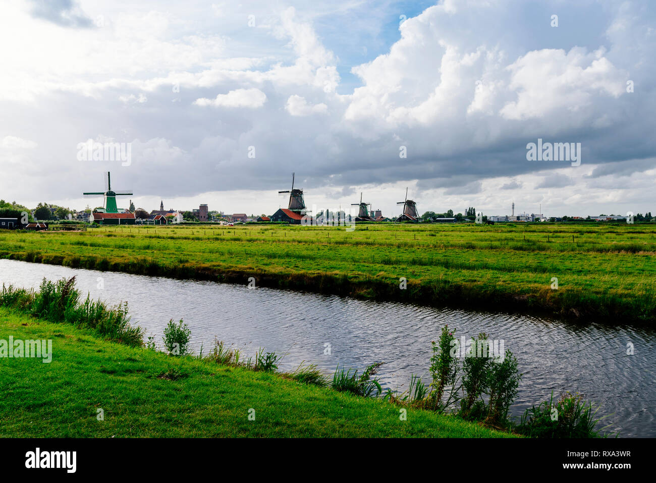 Vue panoramique de canal au milieu du paysage vert contre ciel nuageux Banque D'Images