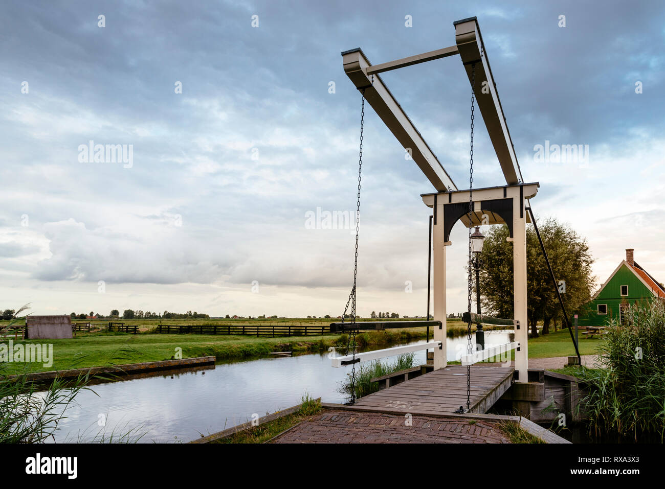 Passerelle sur canal par contre paysage ciel nuageux pendant le coucher du soleil Banque D'Images
