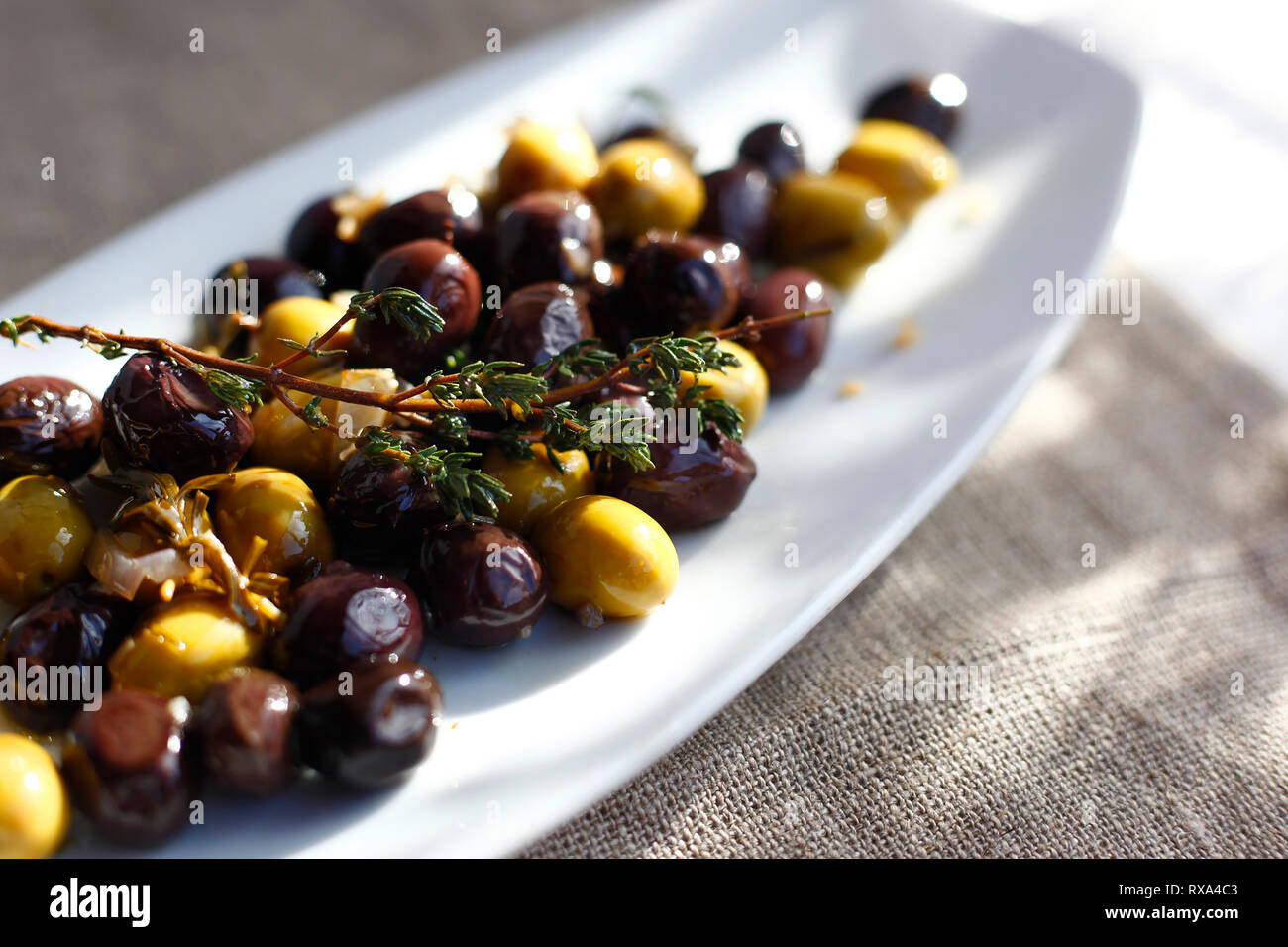 Close-up d'olives aux herbes servi dans la plaque sur la table Banque D'Images