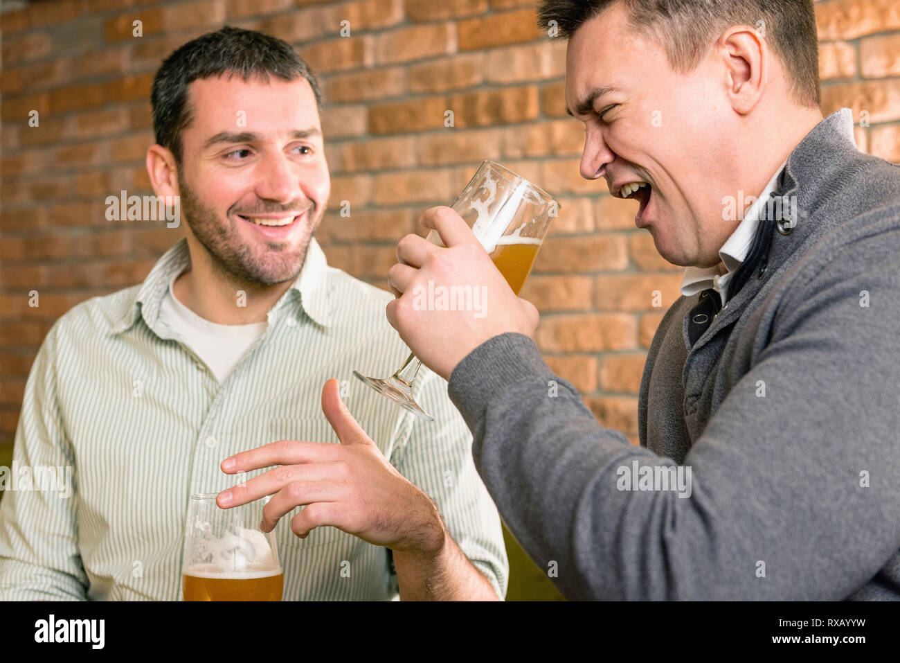 Les amis de boire une bière dans un pub Banque D'Images