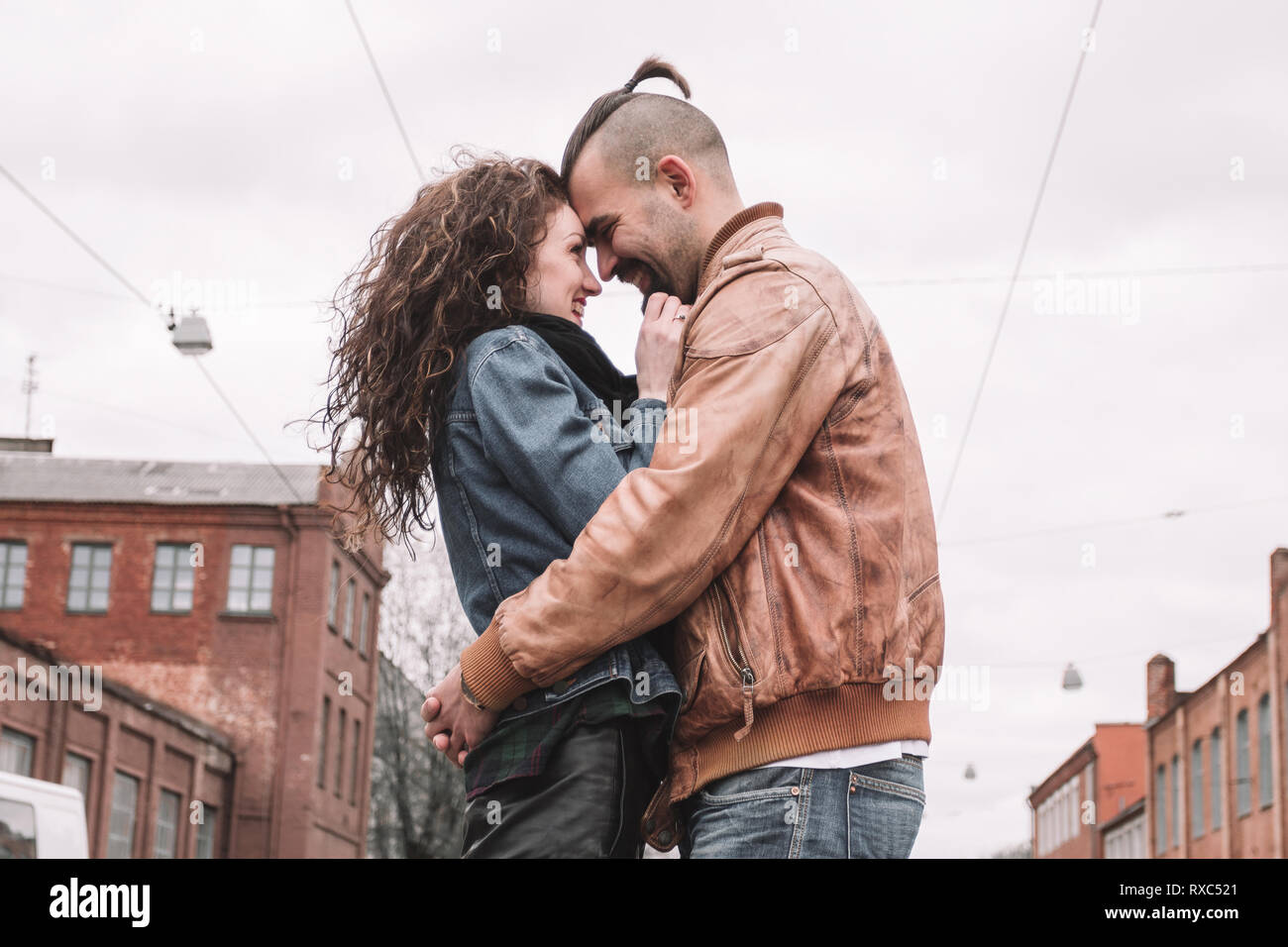 Couple in love hugs mutuellement tout en se tenant sur une rue de la ville Banque D'Images