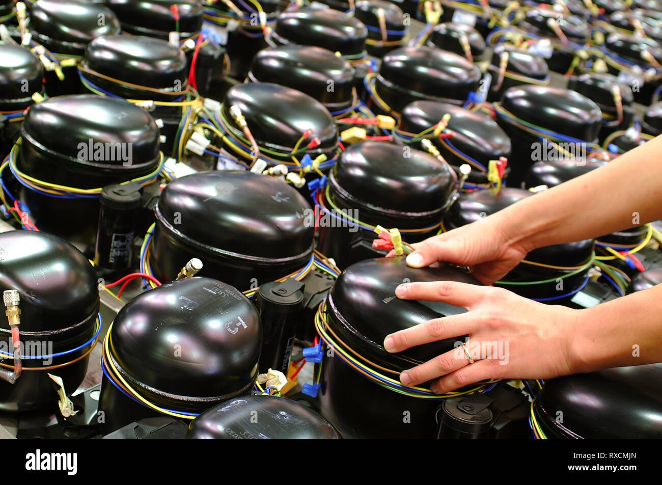 Prendre un travailleur réfrigérateur compresseur avec ses mains Banque D'Images