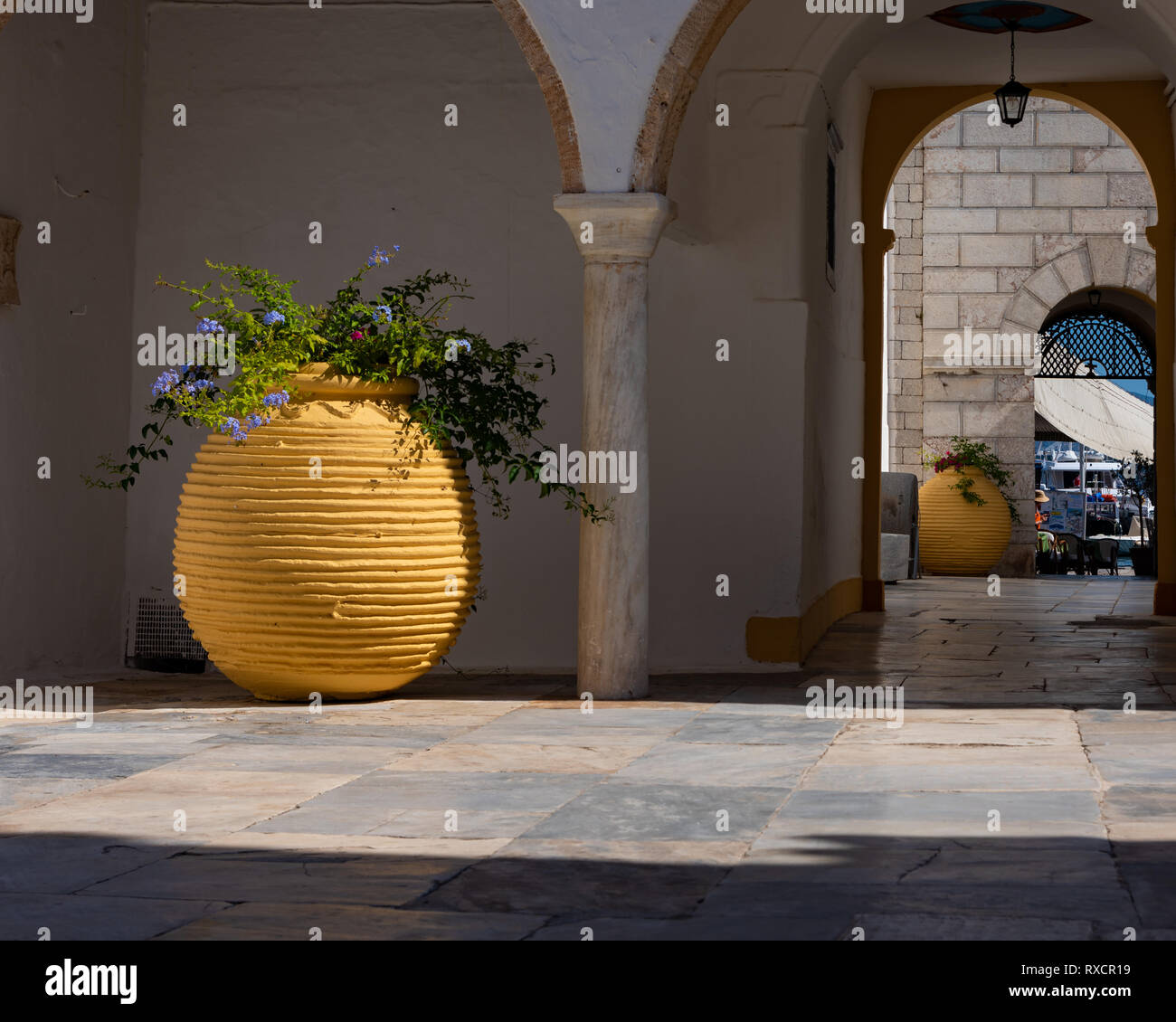 Gros pots jaune dans la cour ouverte à l'île grecque d'Hydra en été Banque D'Images