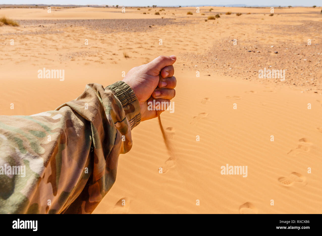 La main des hommes est coulée en sable chute désert du Sahara Banque D'Images