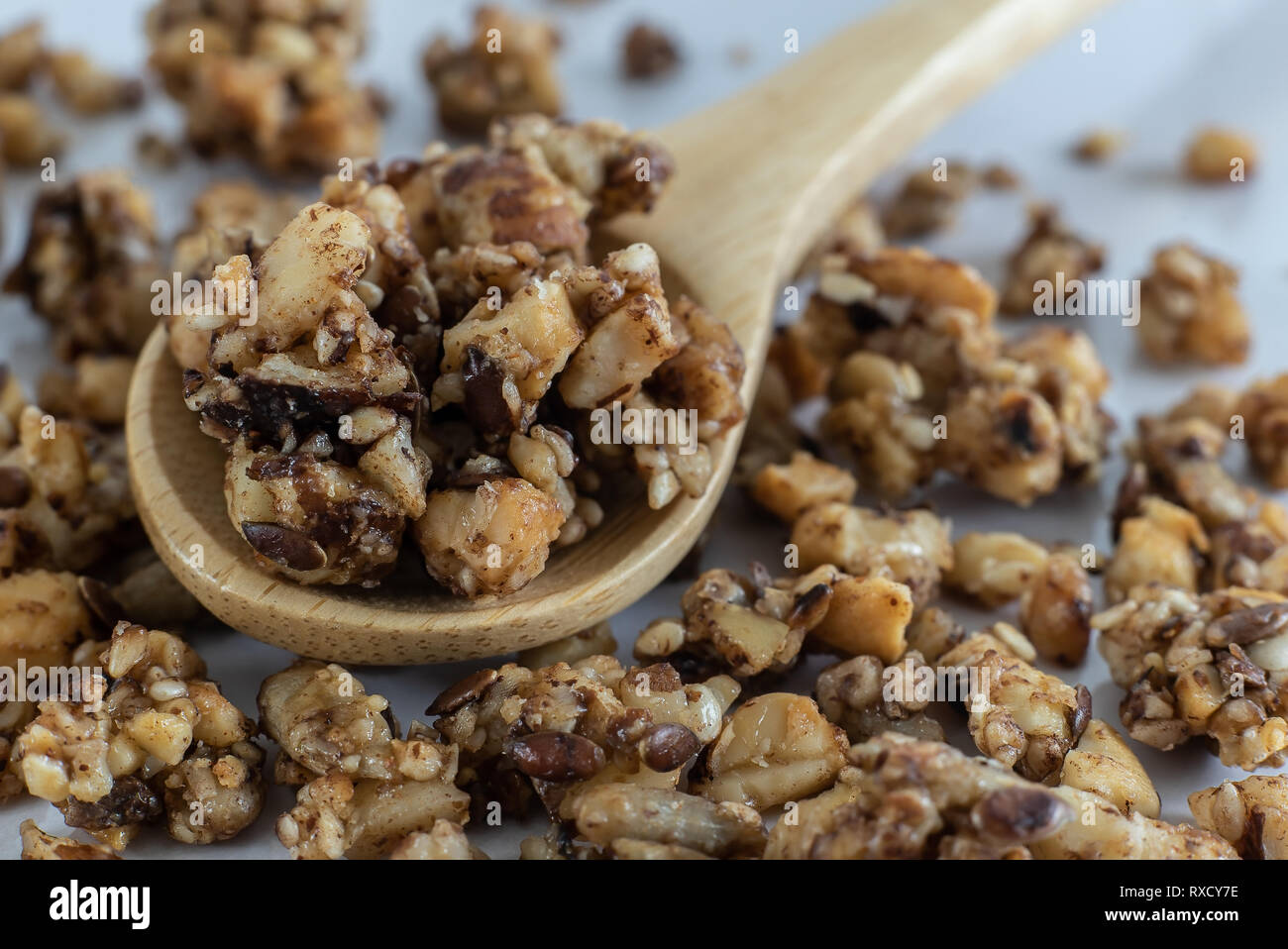 Closeup détail de petit-déjeuner sain et nutritif en granola une cuillère en bois sur la table de cuisine à la lumière du soleil du matin frais. Banque D'Images