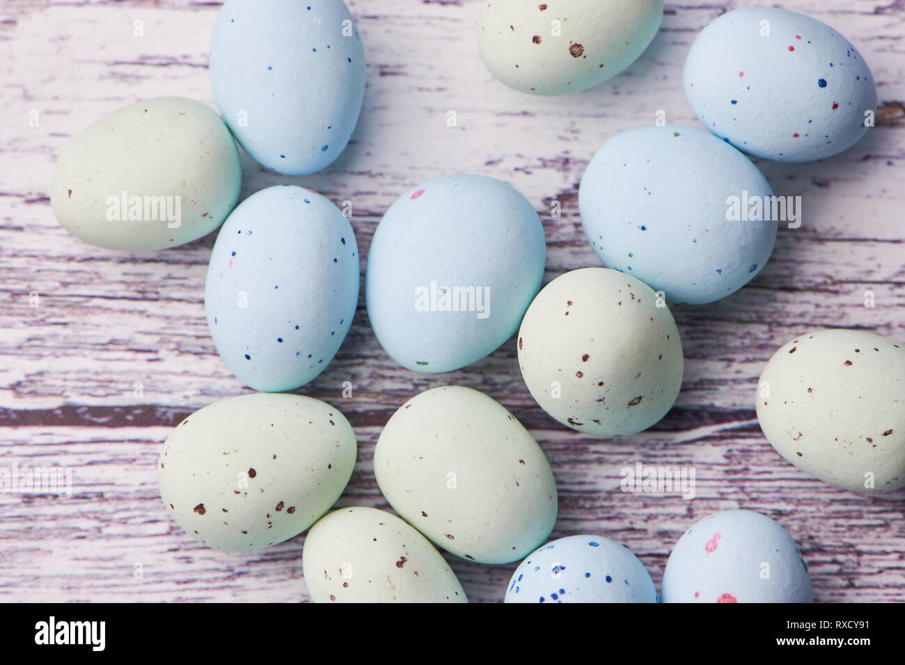 Jaune et bleu sur fond blanc oeufs dragee fond de bois, macro photo couleur Banque D'Images
