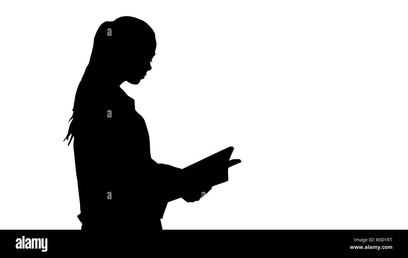 Étudiant en médecine attrayante Silhouette ou un médecin avec un ordinateur portable la marche et la lecture. Banque D'Images