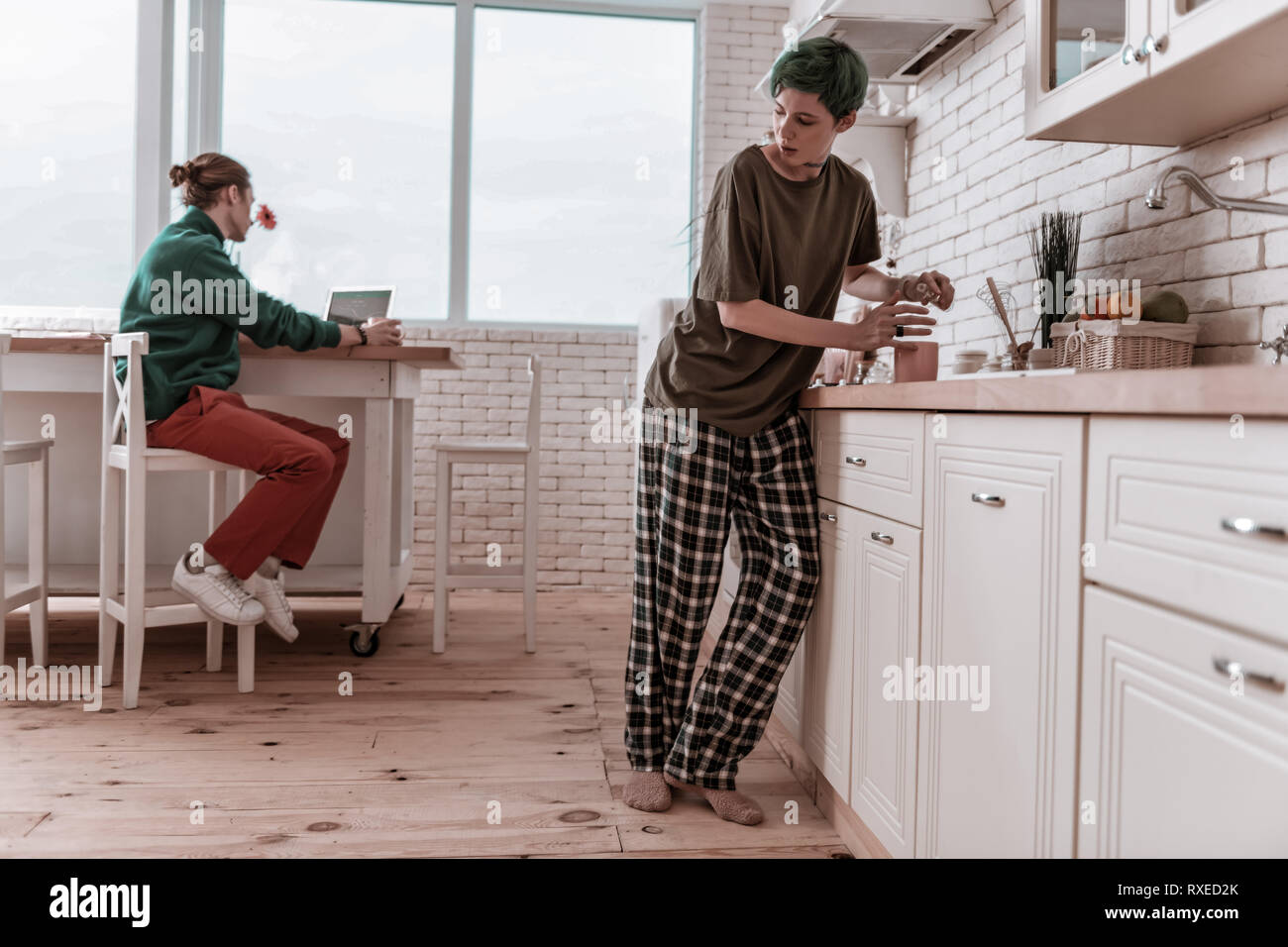 Petite amie wearing pajamas se cacher de l'homme et de l'alcool ? Banque D'Images