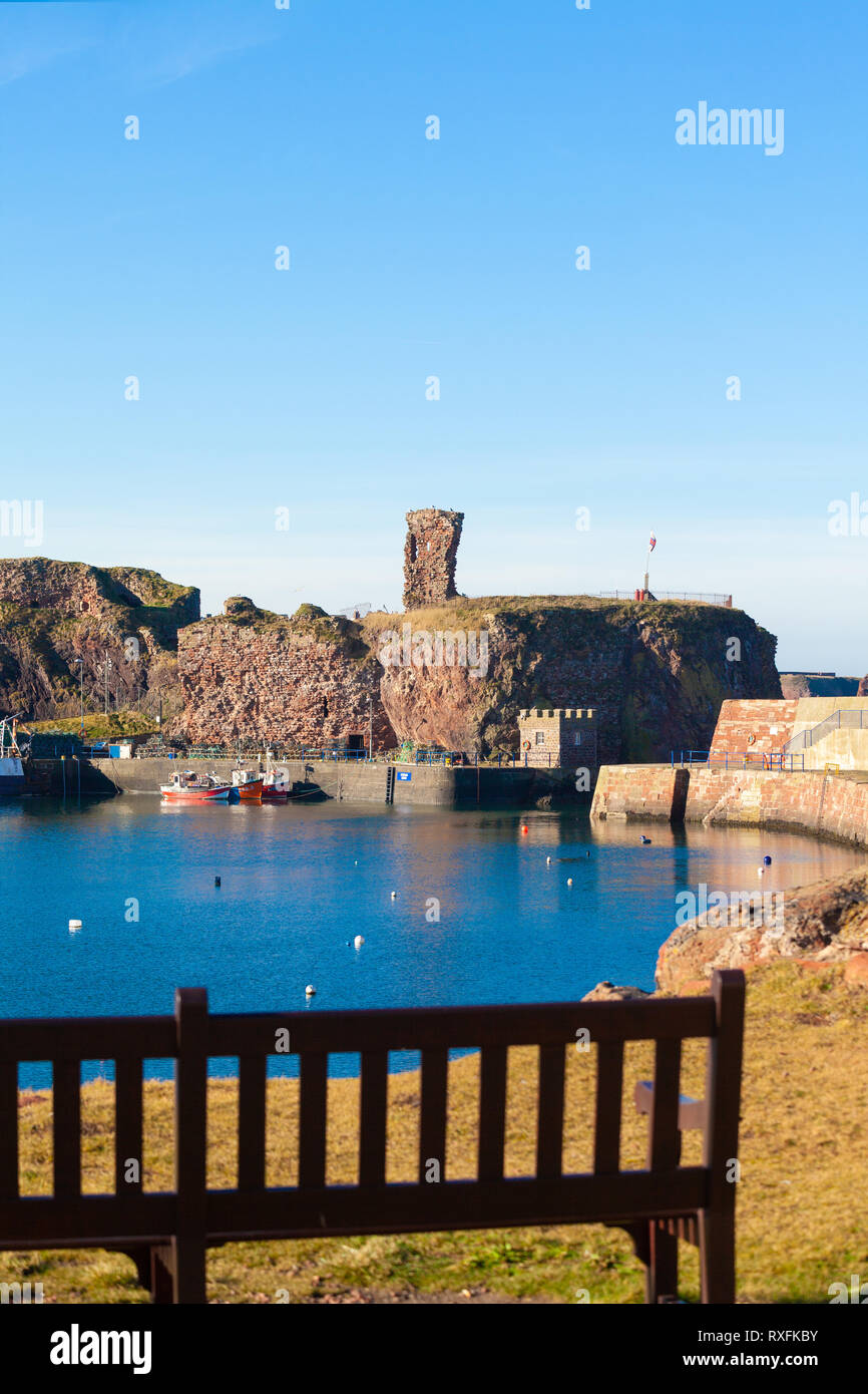 Dunbar Dunbar port et château avec banc de parc au premier plan. l'arrière-plan. Dunbar, East Lothian, Scotland Banque D'Images