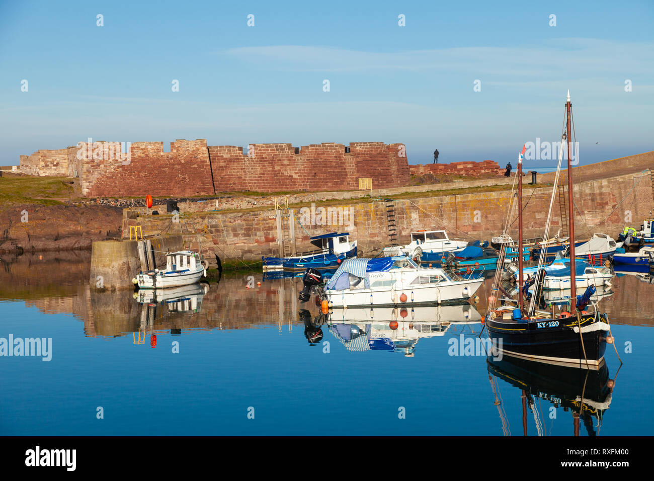Réflexions sur une journée ensoleillée dans le Vieux Port avec Dunbar Dunbar batterie dans l'arrière-plan. East Lothian, Ecosse Banque D'Images