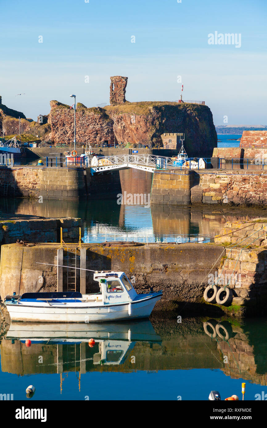 Un bateau amarré dans le port de Victoria avec Dunbar Dunbar Castle dans l'arrière-plan. Dunbar, East Lothian, Scotland Banque D'Images