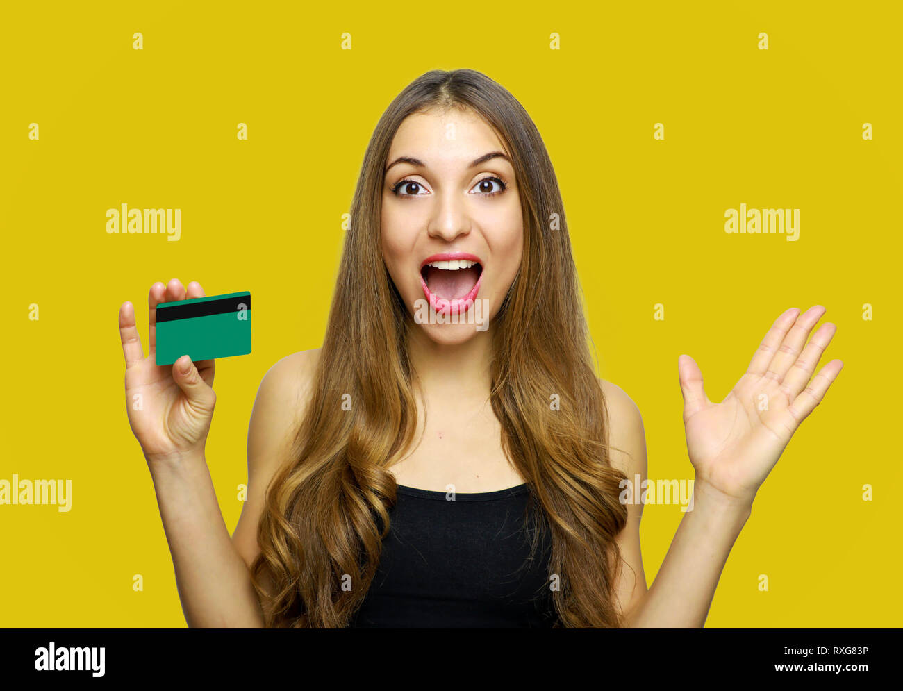 Heureux heureux surpris young woman holding credit card sur fond jaune Banque D'Images