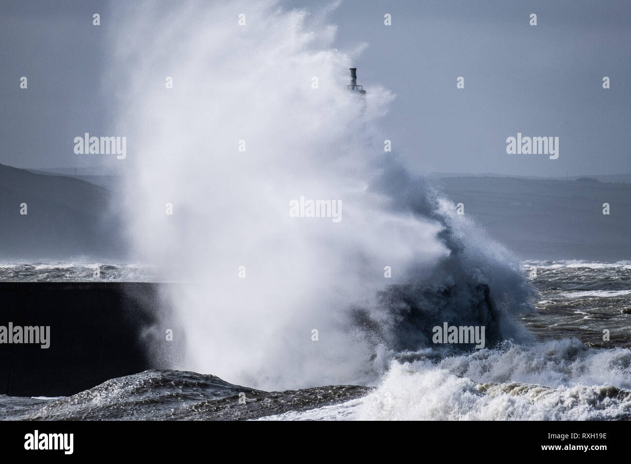 Pays de Galles, Royaume-Uni. 10 mars 2019. Météo France : coup de vent d'ouest avec rafales à plus de 60km/h , et le matin de 4,9m à marée haute , se combinent pour faire d'énormes vagues déferle sur la mer d'Irlande et battues dans la défense de la mer à Aberystwyth, sur la côte de la Baie de Cardigan, West Wales UK Crédit photo : Keith Morris /Alamy Live News Banque D'Images