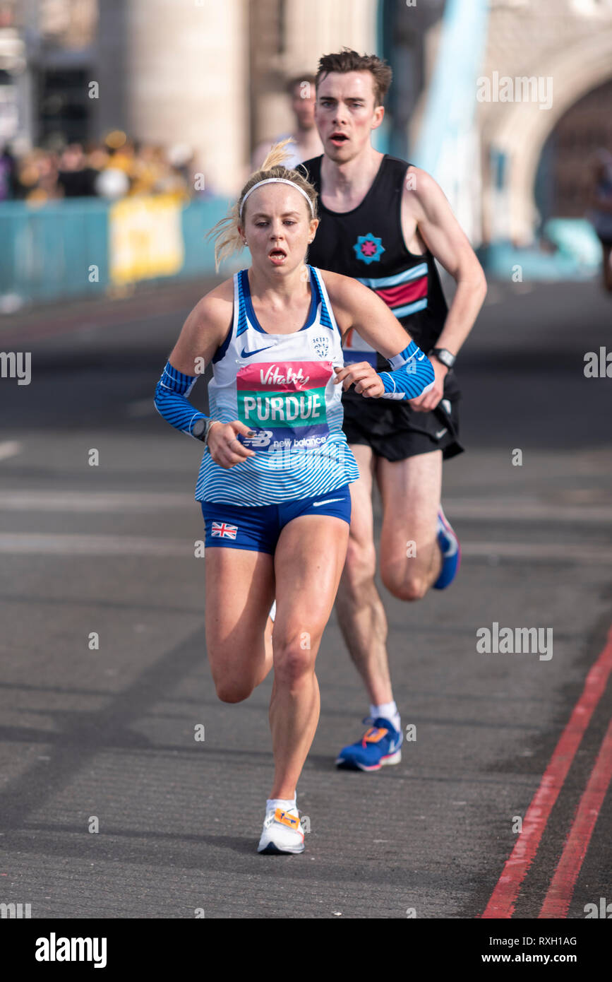 Purdue Charlotte d'exécution dans la grande vitalité de la moitié demi-marathon traversant le Tower Bridge, Londres, Royaume-Uni. Banque D'Images