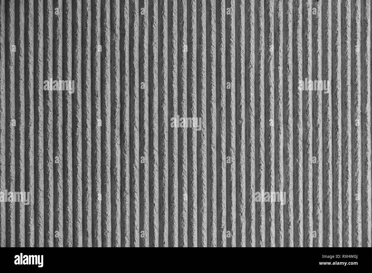 Surface du mur avec un plâtre blanc décoratif. Mur en béton texturé avec des lignes verticales et des bandes comme une texture ou un arrière-plan. La réparation, la conception Banque D'Images