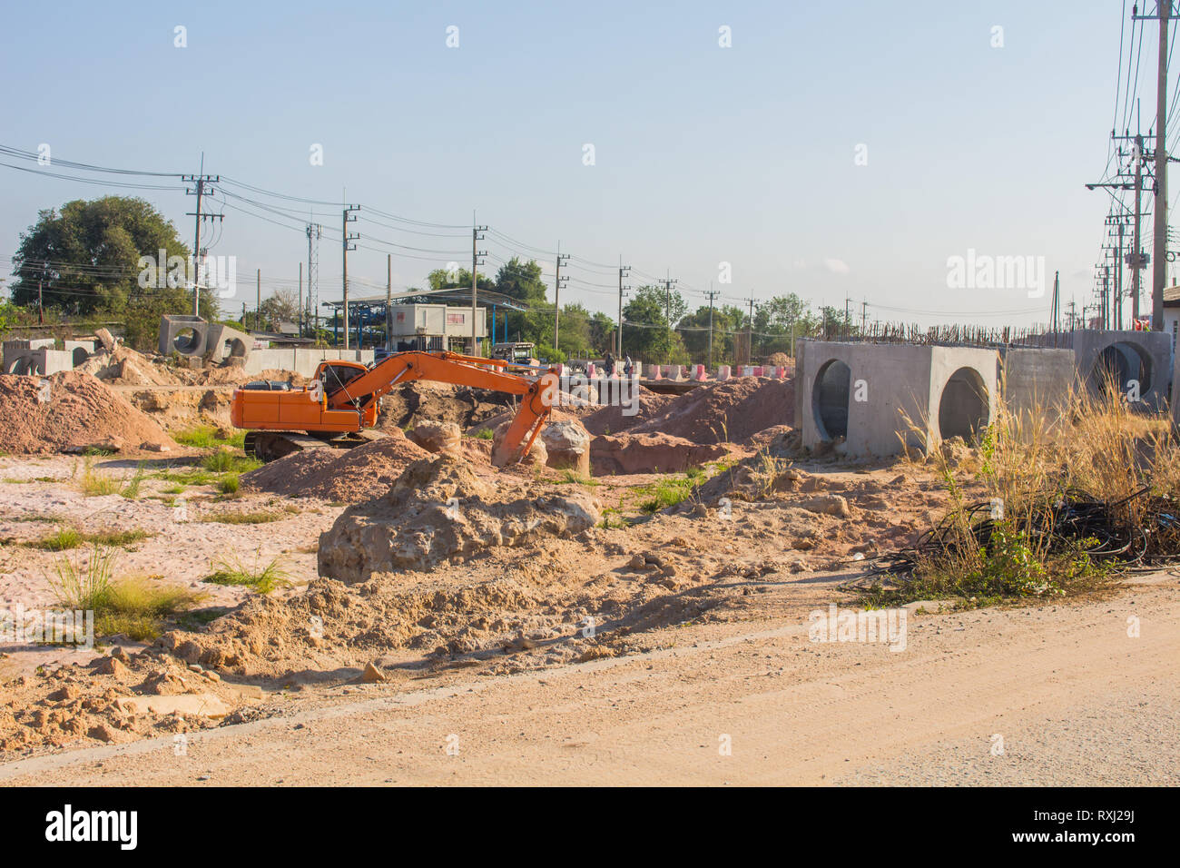 Les pelles sont en train de creuser le sol pour mettre en place un grand tuyau de drainage près de la route dans la zone de la ville Banque D'Images