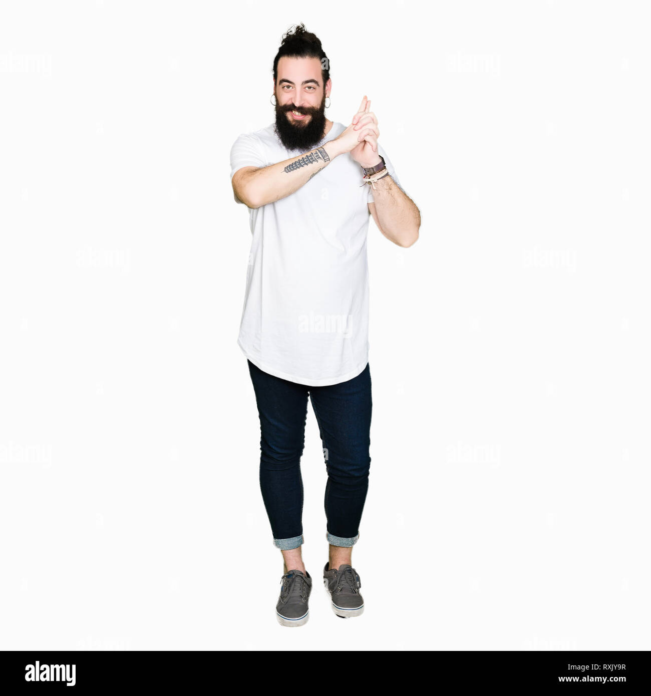 Jeune homme hipster avec de longs cheveux et barbe porter Casual t-shirt blanc avec des armes à feu symbolique Holding hand gesture, jouer à tuer les armes de tir, l'angr Banque D'Images